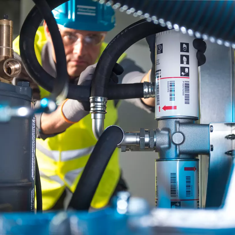Technician inspecting hydraulic filter assembly